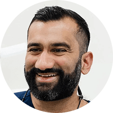 A smiling male dental professional in a circular portrait photo