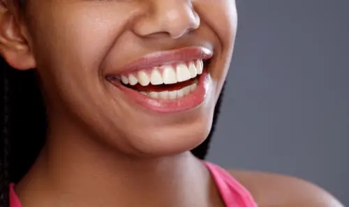 A close-up of a woman's radiant smile with naturally white, even teeth